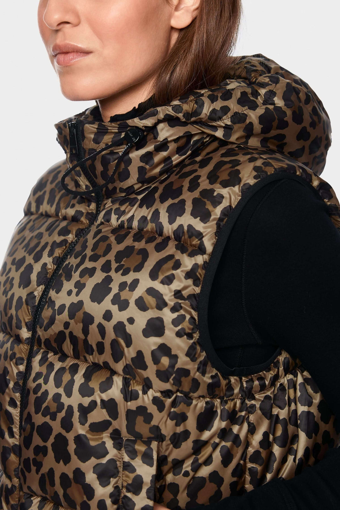 Veste matelassée à imprimé léopard et capuchon portée par une femme, mettant en valeur l'élégance et confort du vêtement.
