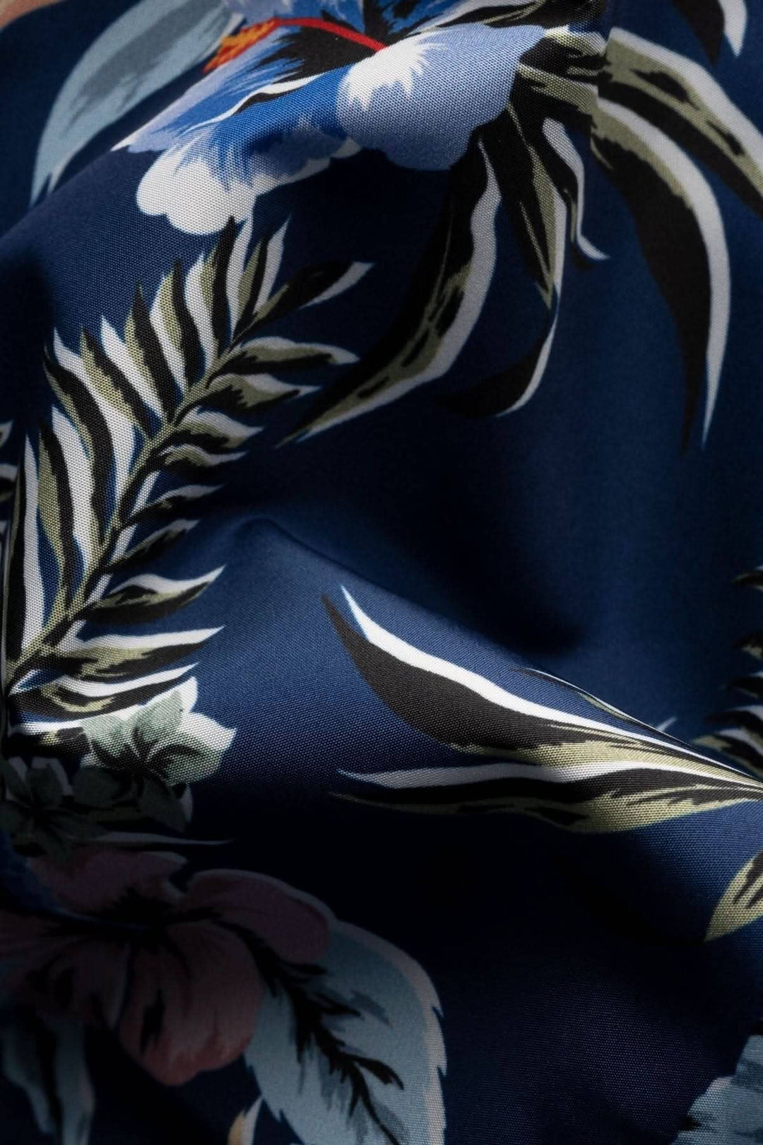 Tissu polyester italien à imprimé floral vibrant sur fond bleu, idéal pour maillot de bain.