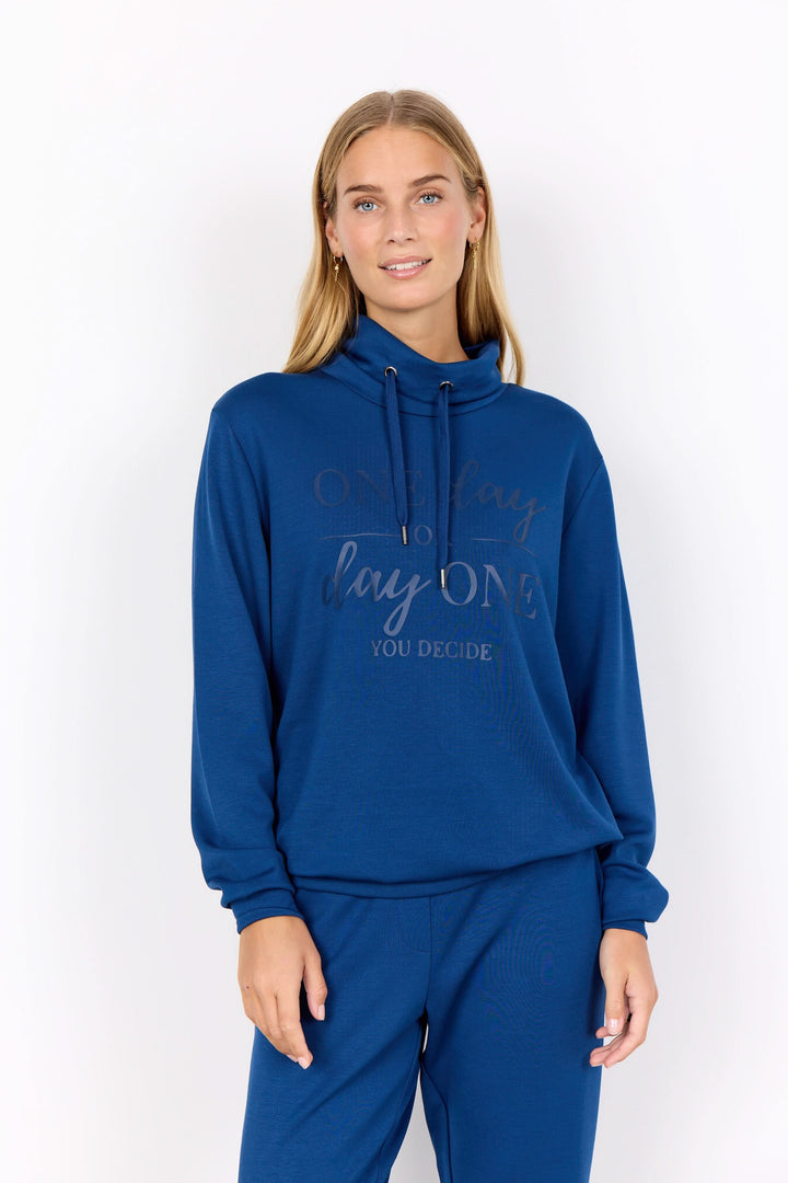 Chandail col montant bleu avec message positif, manches longues et cordons ajustables.