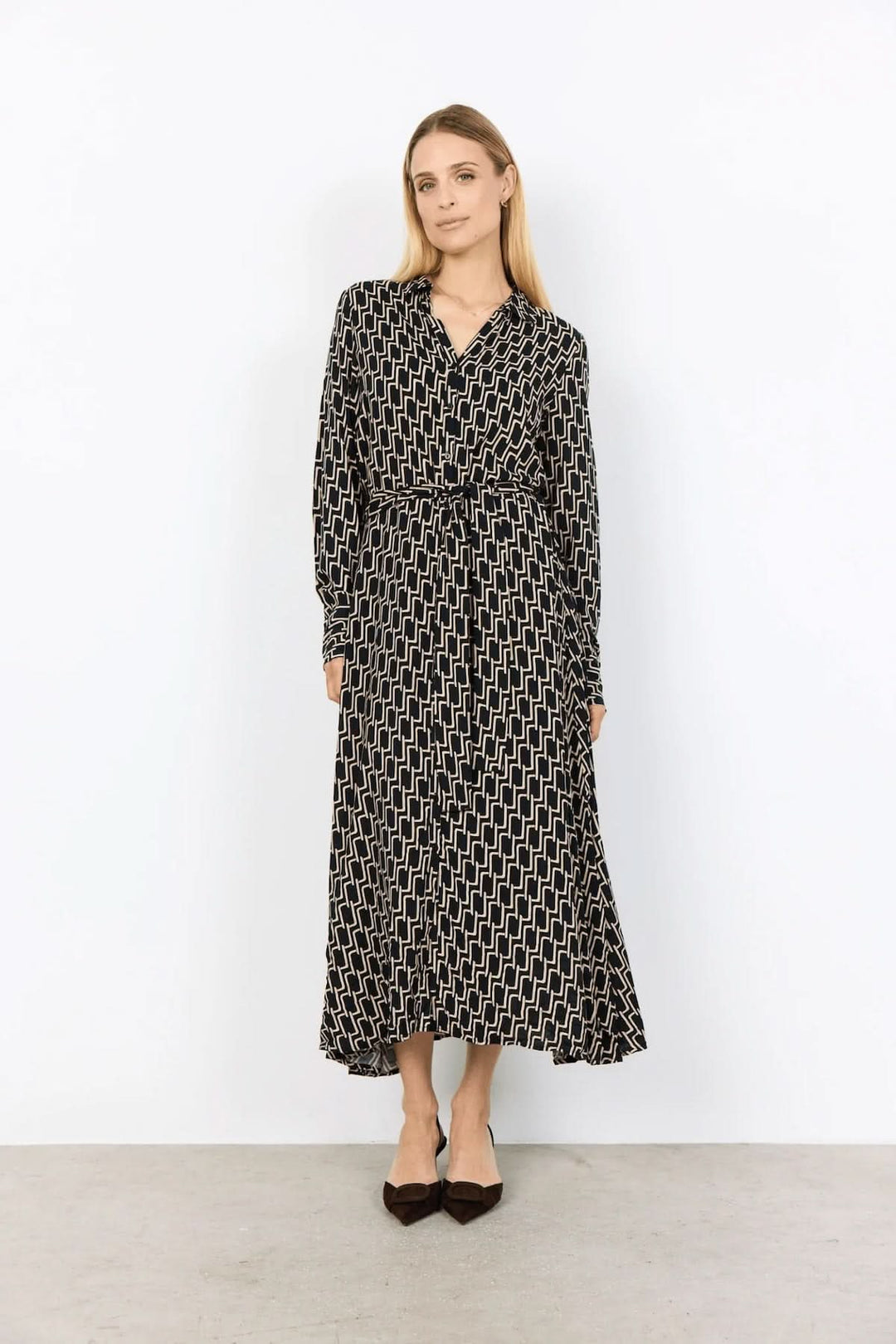 Robe chemisier fluide avec imprimé graphique rétro, coupe midi, ceinture à nouer et élégance intemporelle.