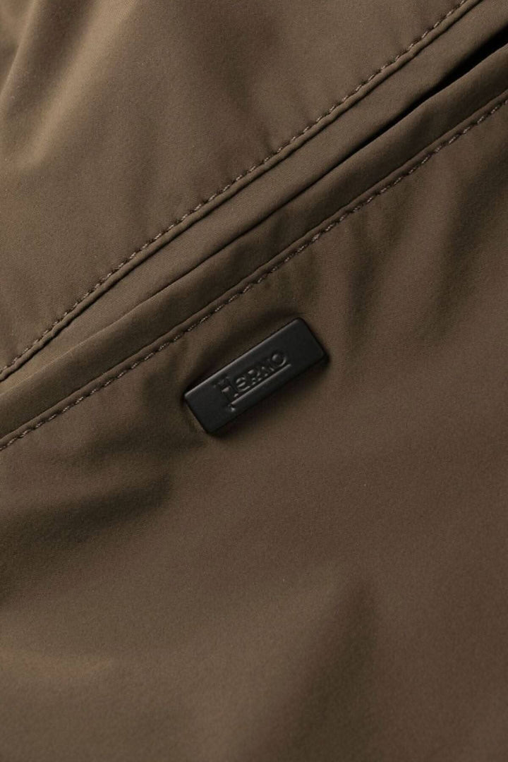 Détail d'une étiquette en cuir sur un pantalon en nylon, couleur marron, de la collection Herno Laminar.