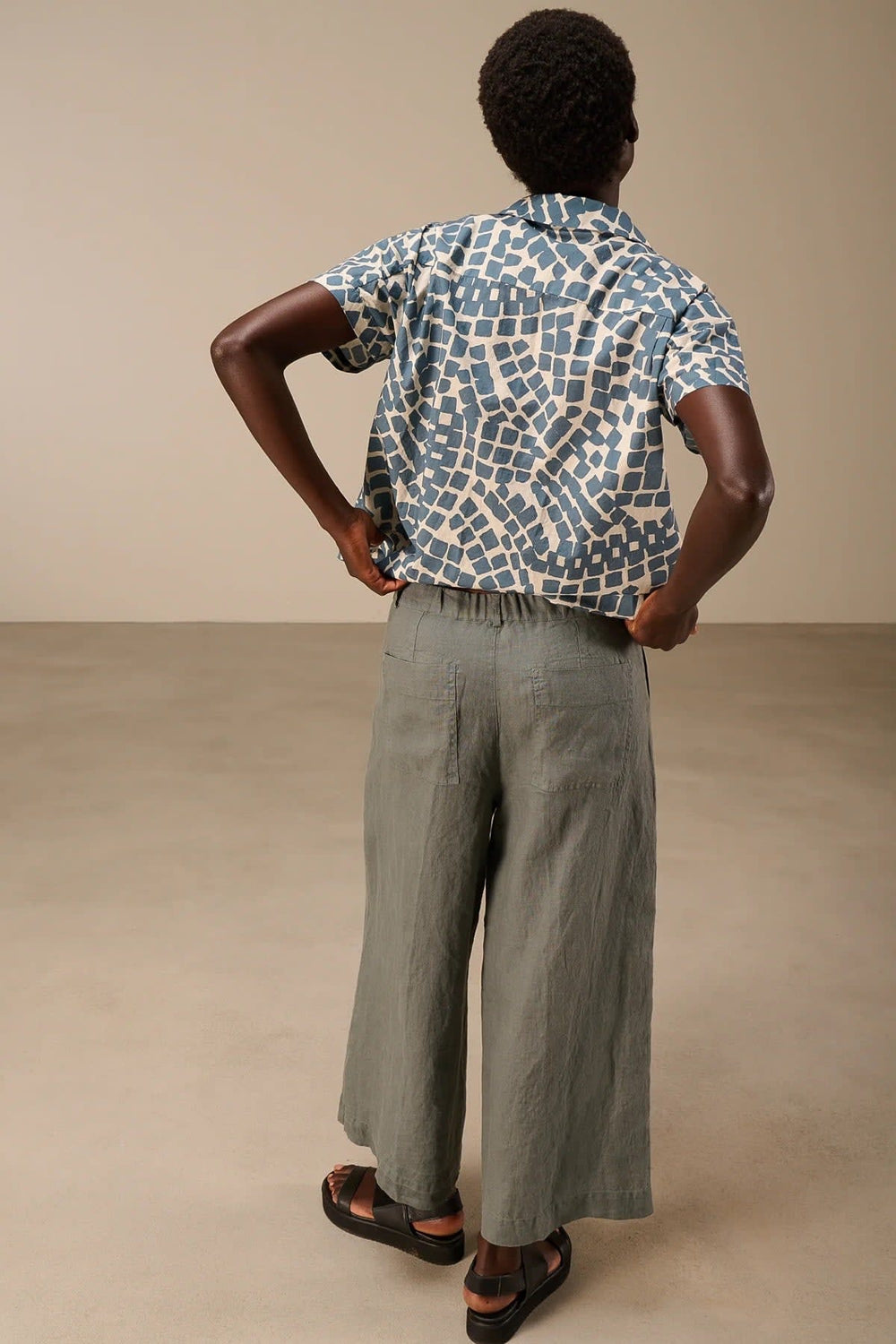 Vue de côté pantalon large en lin beige avec plis et ceinture tressée Nile pour femme - Valérie Simon