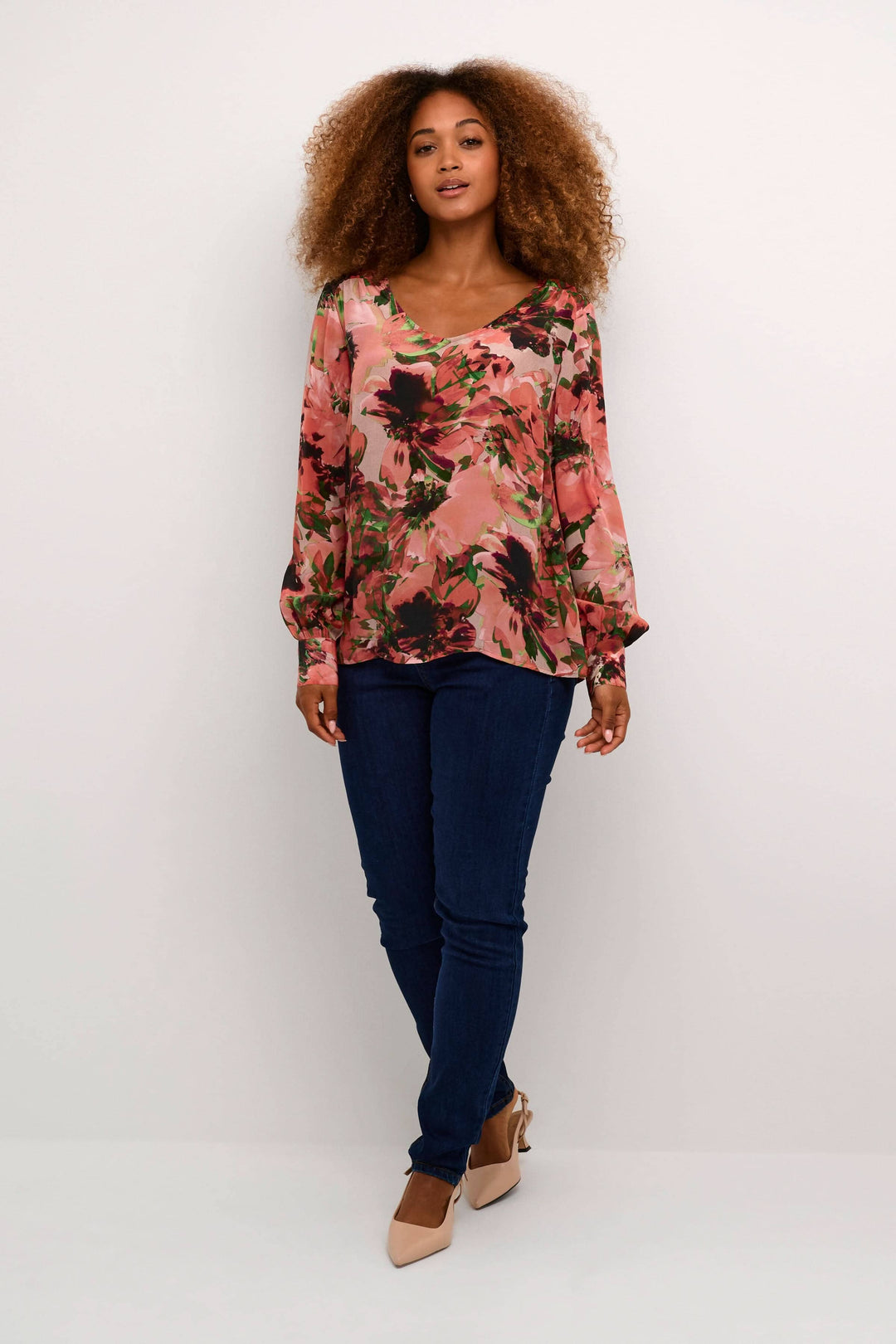 Blouse imprimée avec fleurs, manches longues, encolure en V, portée avec un jean, style décontracté.