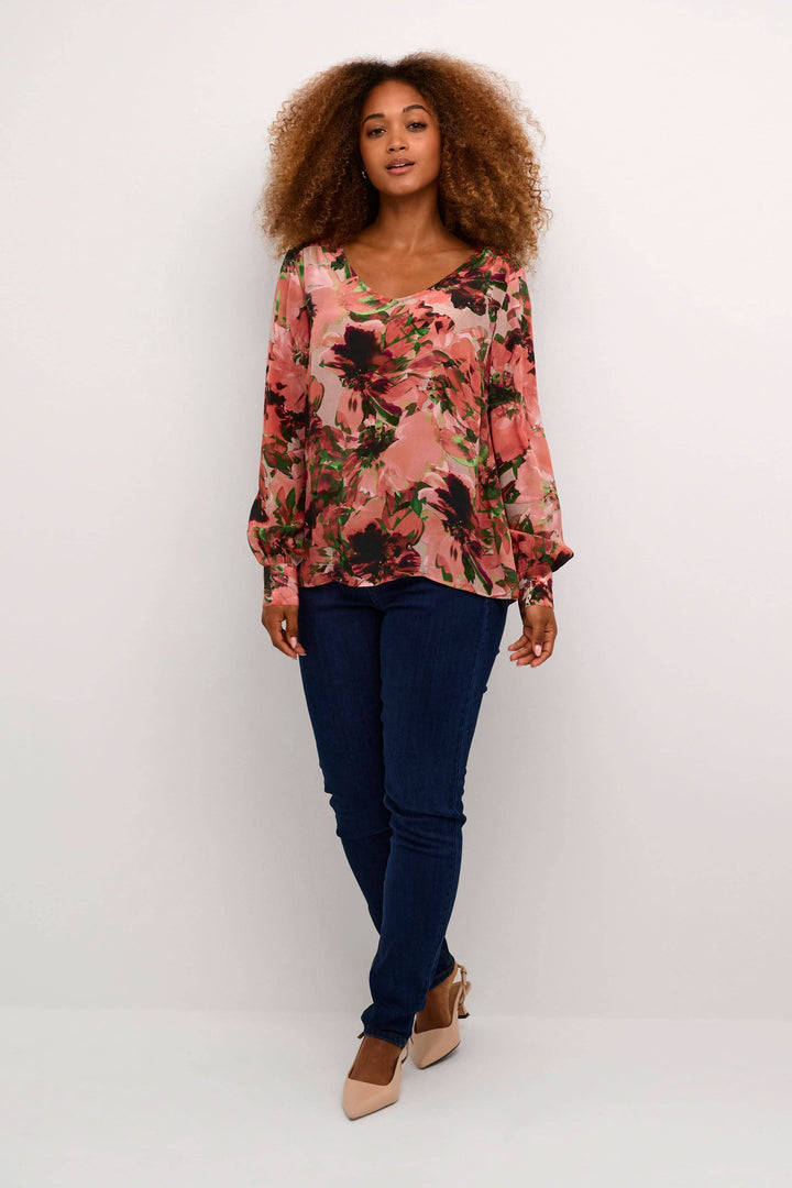 Blouse imprimée avec fleurs, manches longues, encolure en V, portée avec un jean, style décontracté.