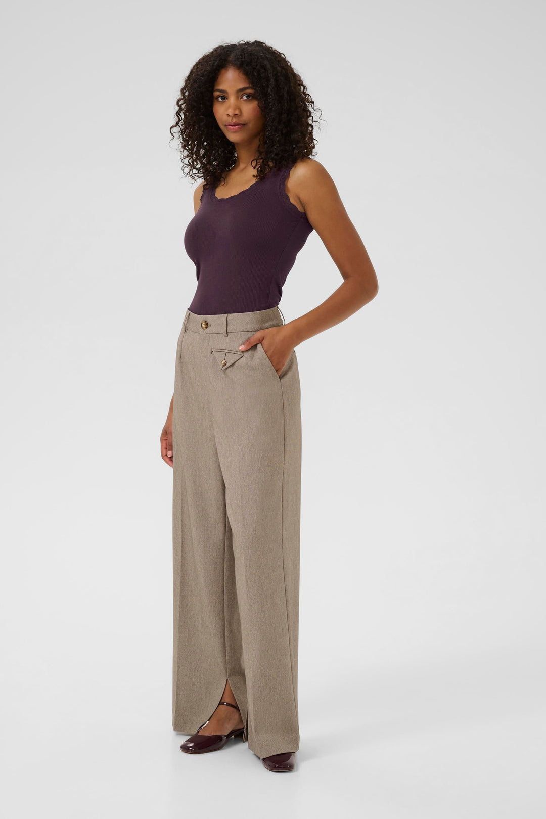 Camisole Omi en violet portée avec un pantalon large beige, stylée et élégante pour un look d'été.