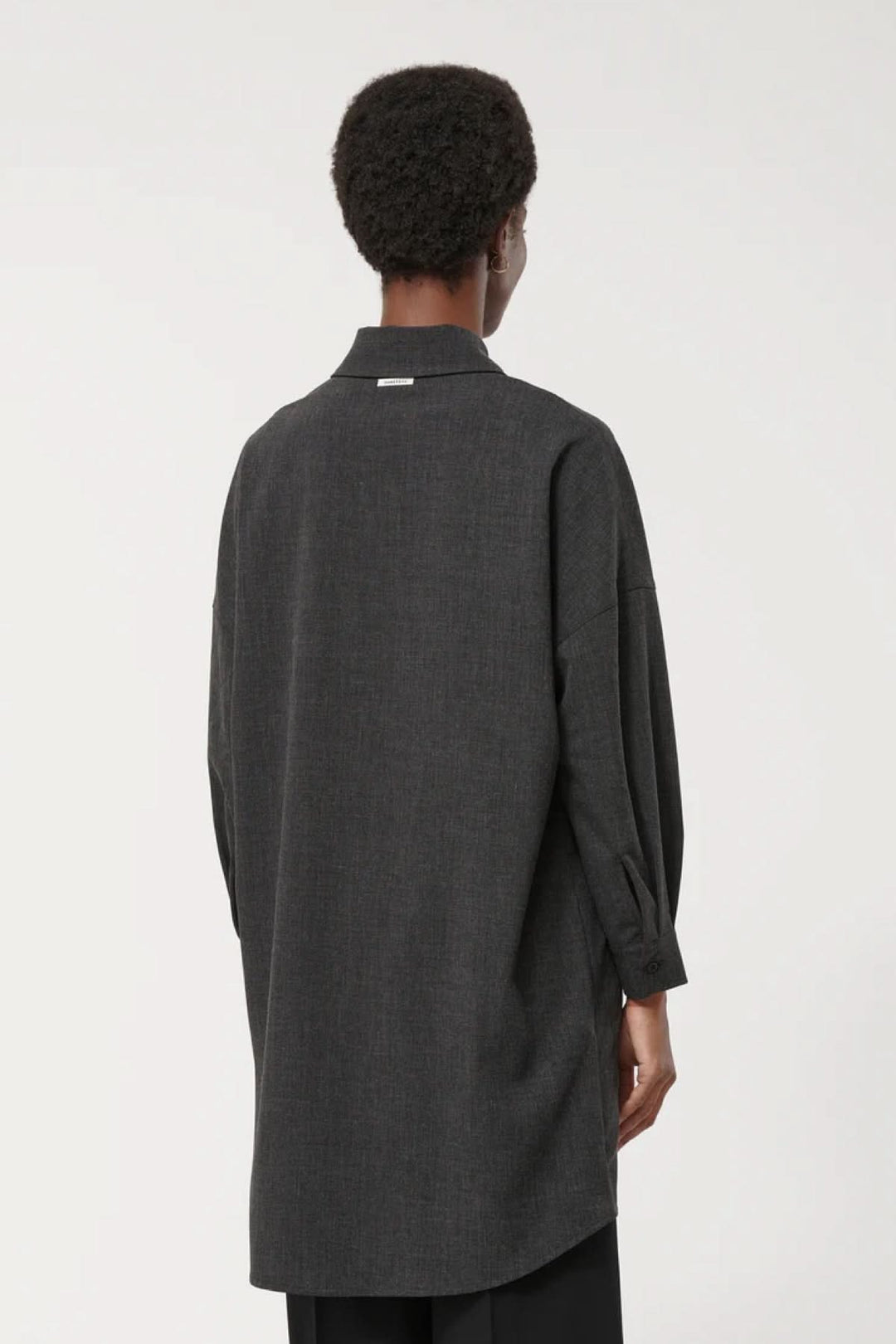 Vue arrière de la robe à manches longues, coupe ample et col classique, design minimaliste.