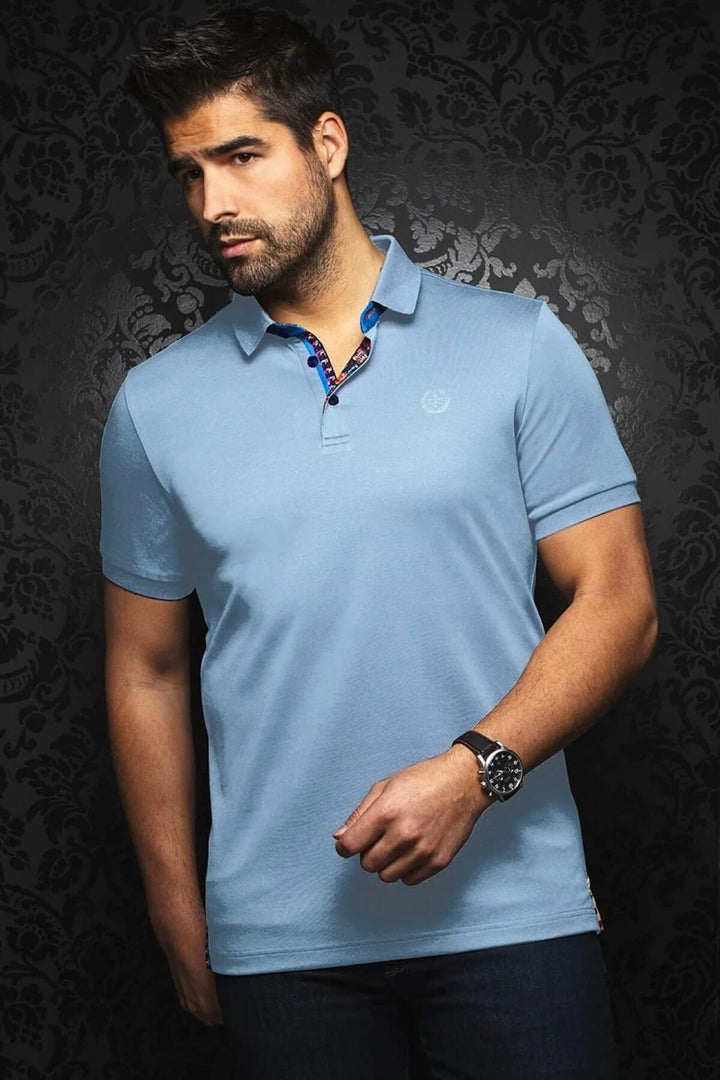 Homme portant un polo bleu uni avec détail contrastant, style sport élégant sur fond noir.