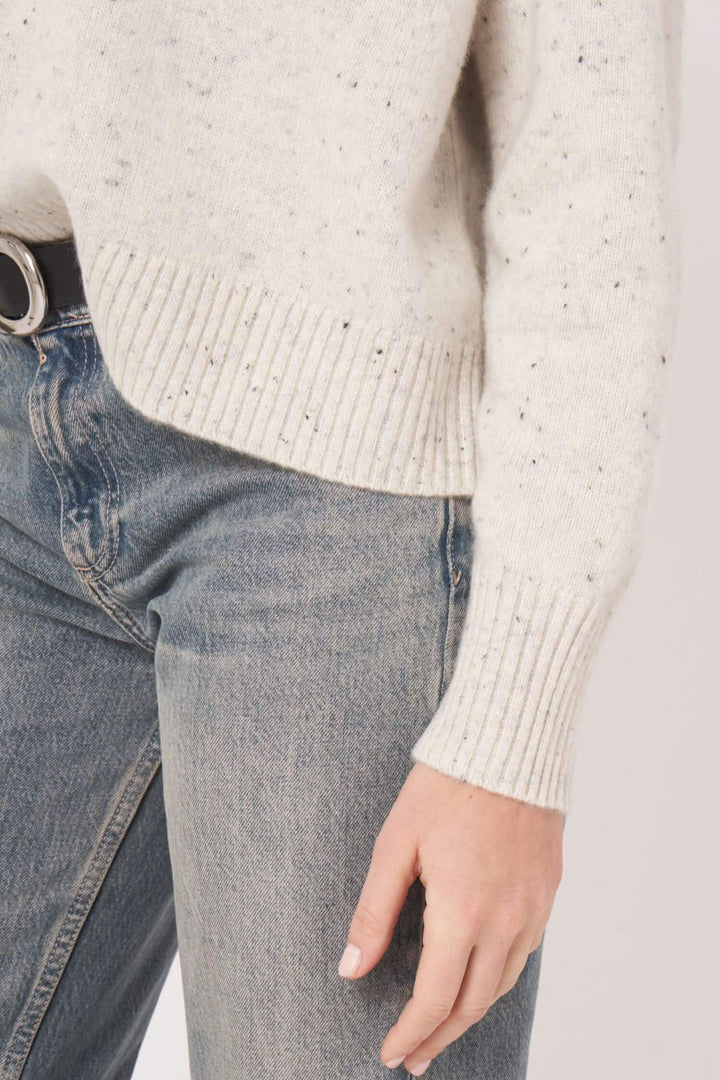 Chandail moucheté en cachemire, coupe ample, associé à un jean délavé, style décontracté et élégant.