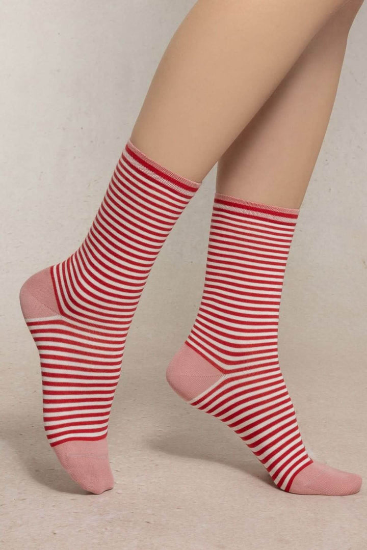 Chaussettes à rayures fines rouges et blanches avec pointe et talon contrastés, portées pour un look moderne et élégant.