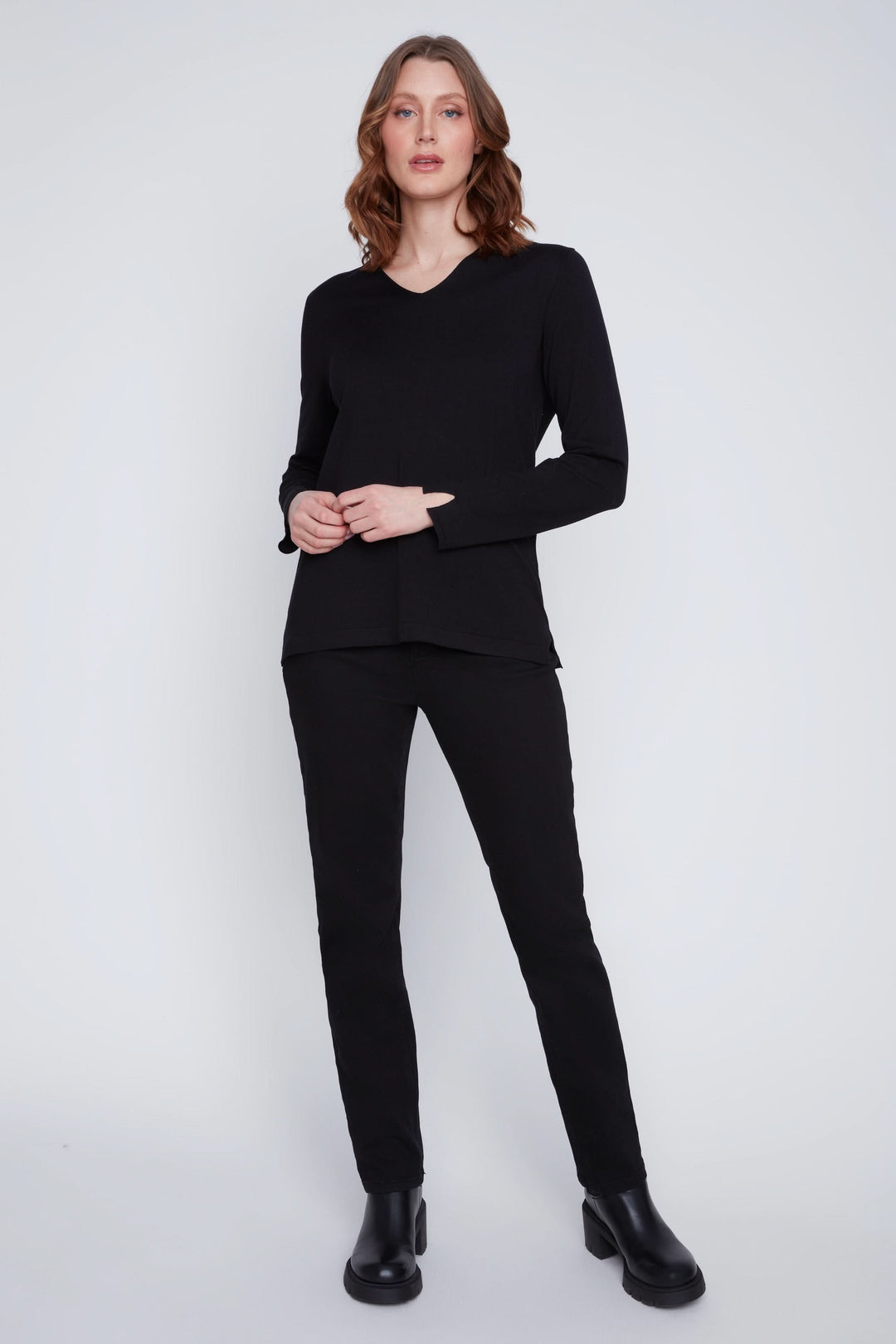 Chandail col V noir à manches longues avec pantalon noir, look chic et minimaliste.