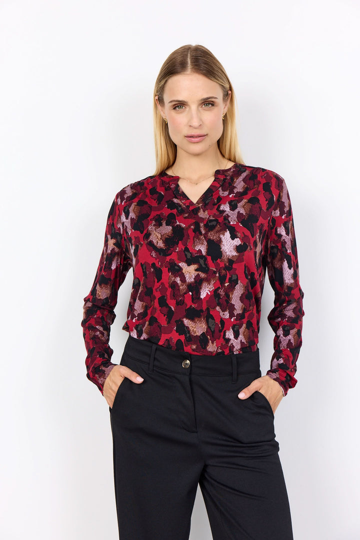 Blouse imprimée à motif abstrait, encolure fendue, style fluide avec un look féminin élégant.