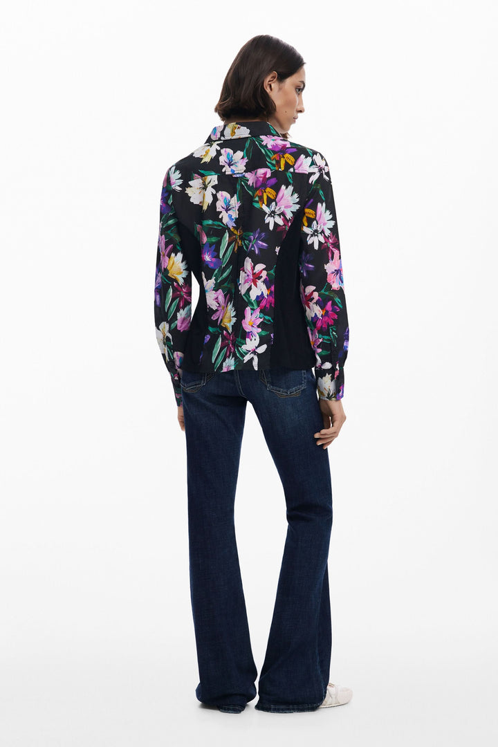 Chemise à fleurs ajustée avec teintes éclatantes, portée par une femme en jean, vue de dos.