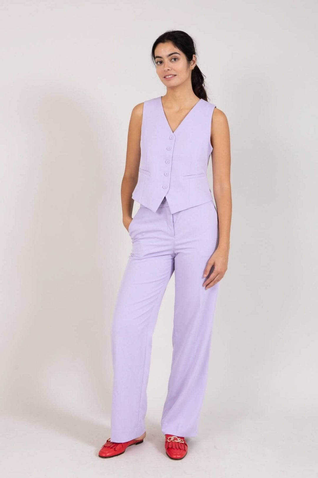 Femme en pantalon à jambes larges et veston violet, style chic et décontracté, parfait pour bureau ou évènement.