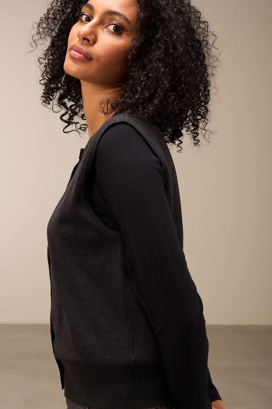 Femme portant une veste sans manches élégante avec une coupe droite, style chic et polyvalent.