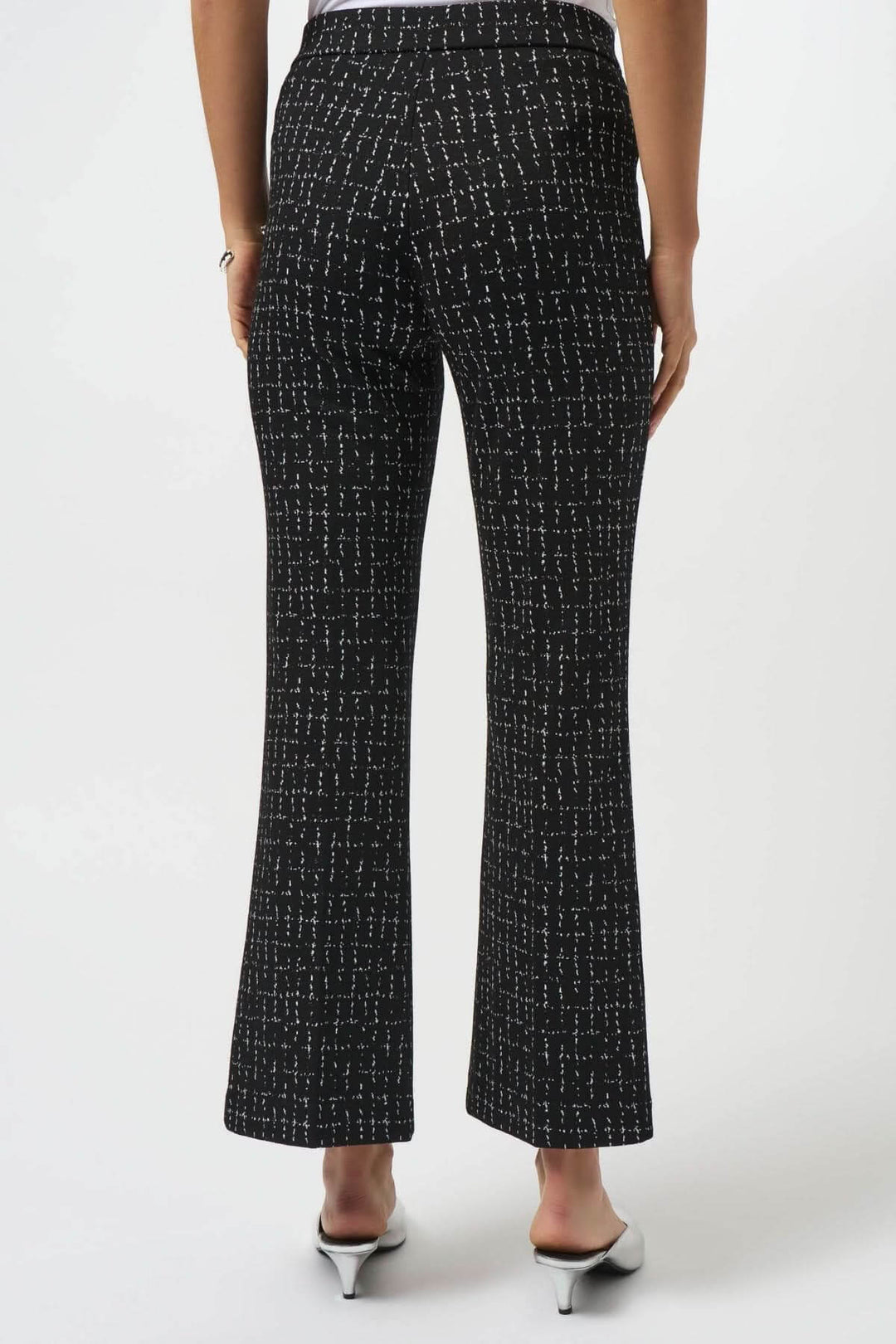 Pantalon noir à jambe évasée avec motif quadrillé blanc, vu de dos, élégant et moderne.