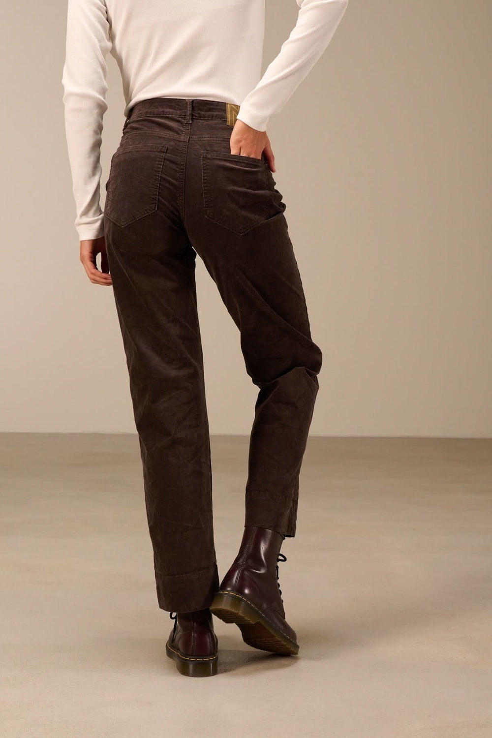 Homme portant un Pantalon en velours côtelé coupe droite marron, associé à des bottines, offrant un style décontracté et authentique.
