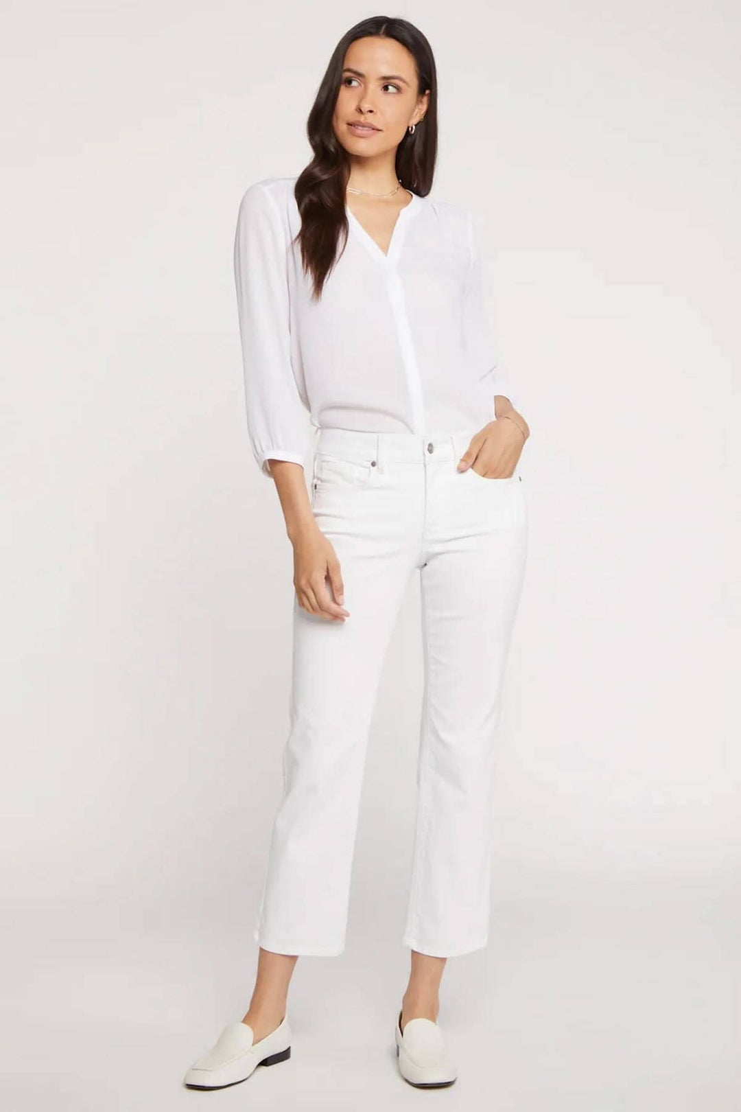 Femme portant le pantalon Marilyn blanc, style classique avec blouse blanche, look élégant et décontracté.