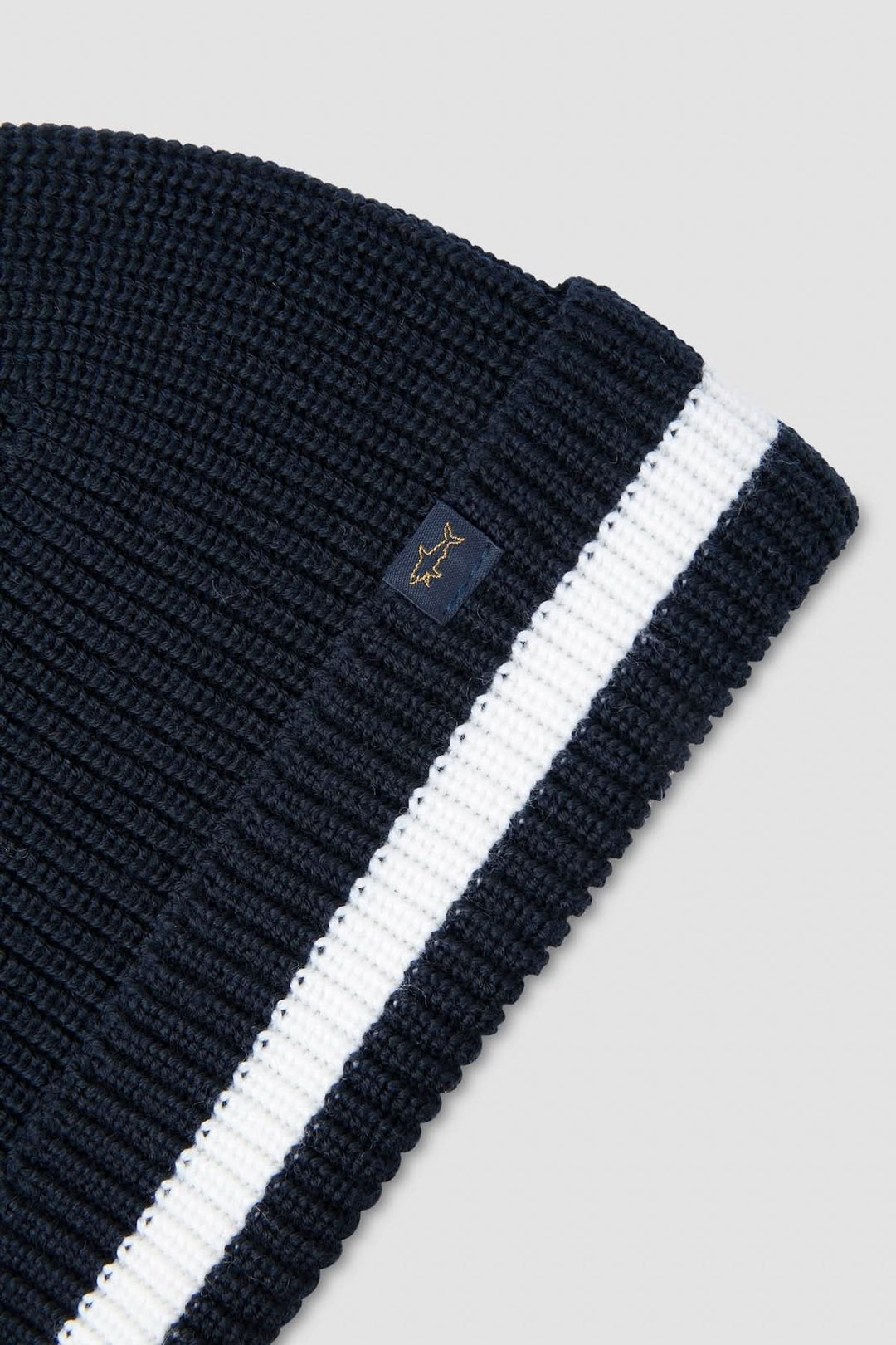Tuque douce en tricot côtelé avec bande contrastante blanche, idéale pour un look hivernal élégant.
