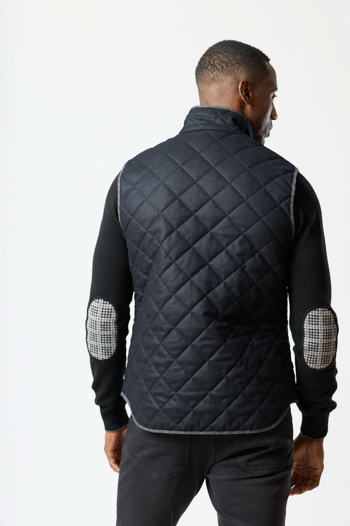 Homme portant une veste sans manches matelassée en laine Vitale Barberis, vue de dos, élégante et moderne pour superposer des vêtements.