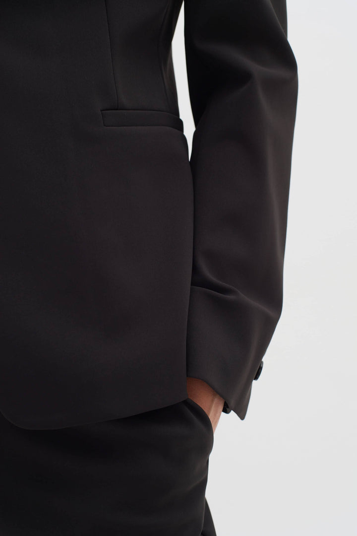 Veston de voyage Zeal en tissu noir, coupe slim, avec poches passepoils et détails classiques.