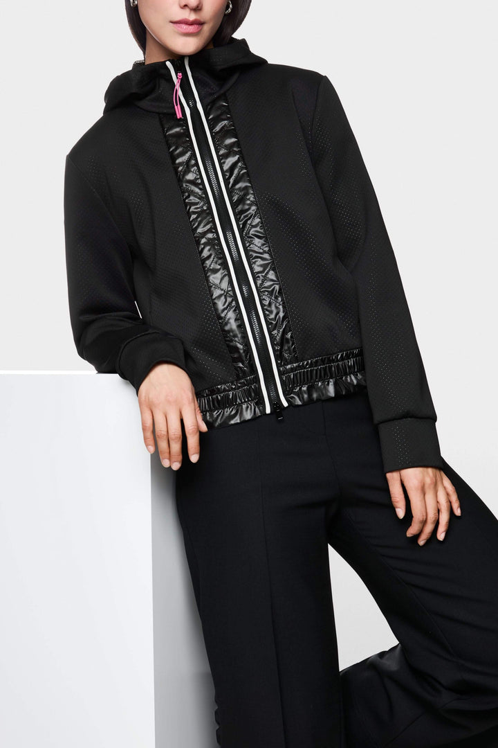 Veste à rayures contrastées, zippée avec capuchon, empiècements brillants et taille élastiquée, style moderne.