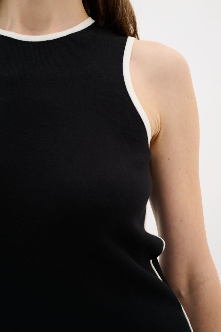 Camisole noire sans manches avec encolure ronde et liseré contrastant, coupe ajustée et tissu doux.