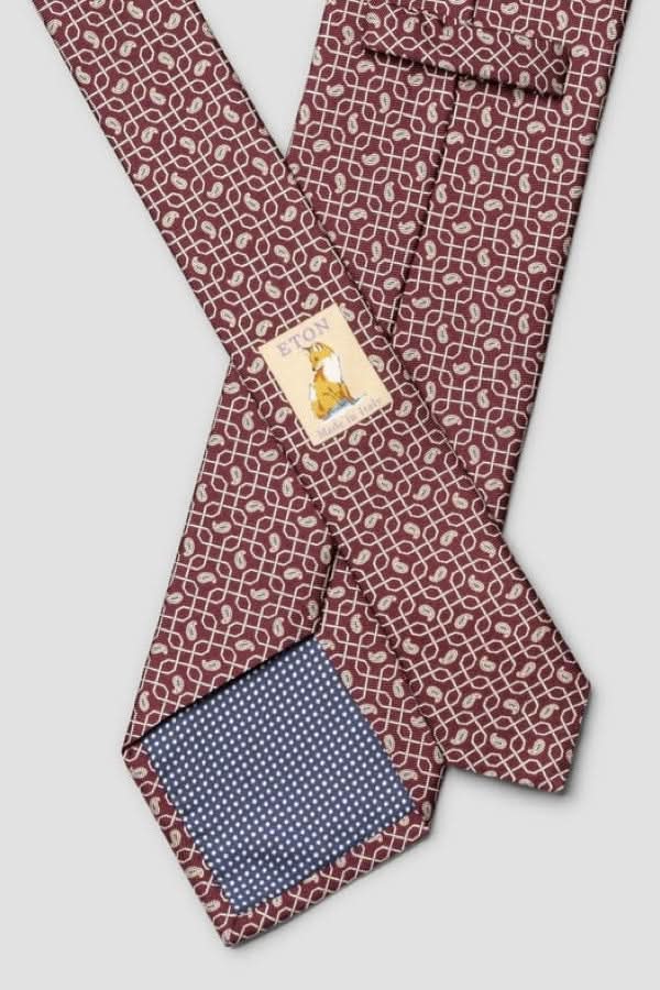 Cravate à motif géométrique en soie italienne avec doublure contrastante, finition lustrée. Parfaite pour occasions professionnelles et élégantes.