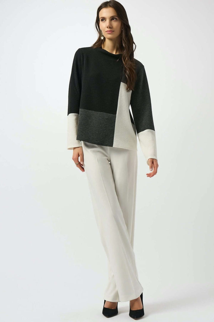 Haut à manches longues en maille texturée, design graphique en blocs de couleurs noir, gris et blanc cassé.