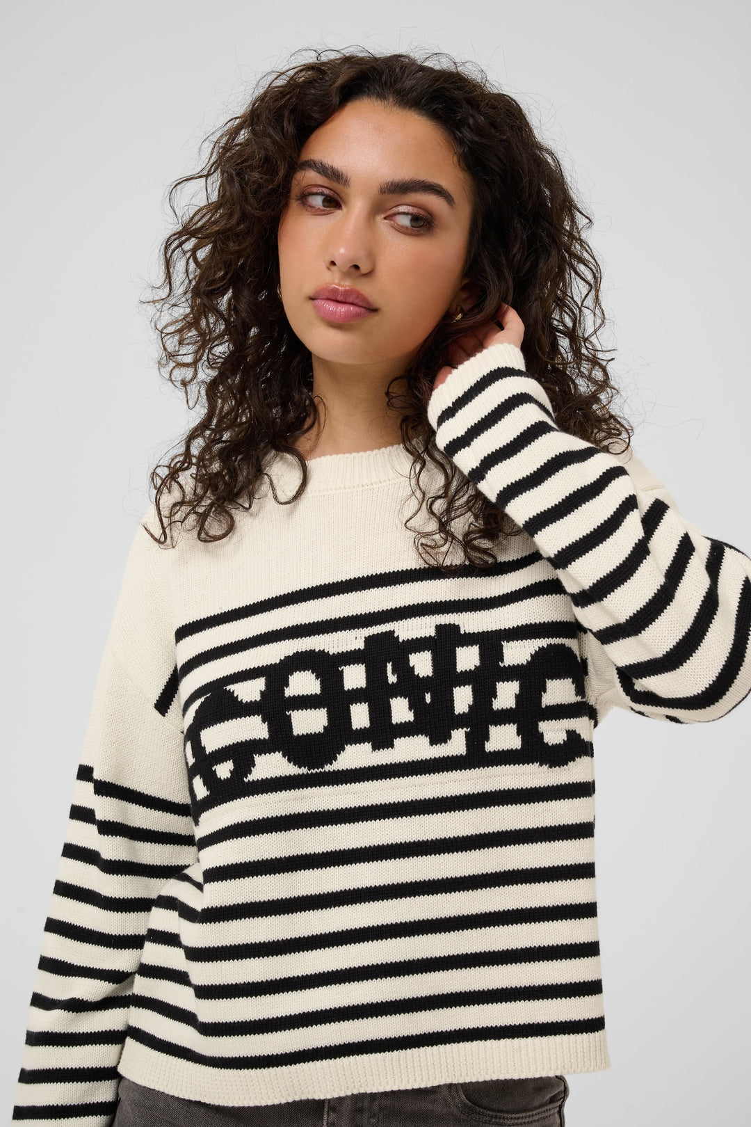 Front view of a striped knit sweater with "Kaffe" lettering, women&