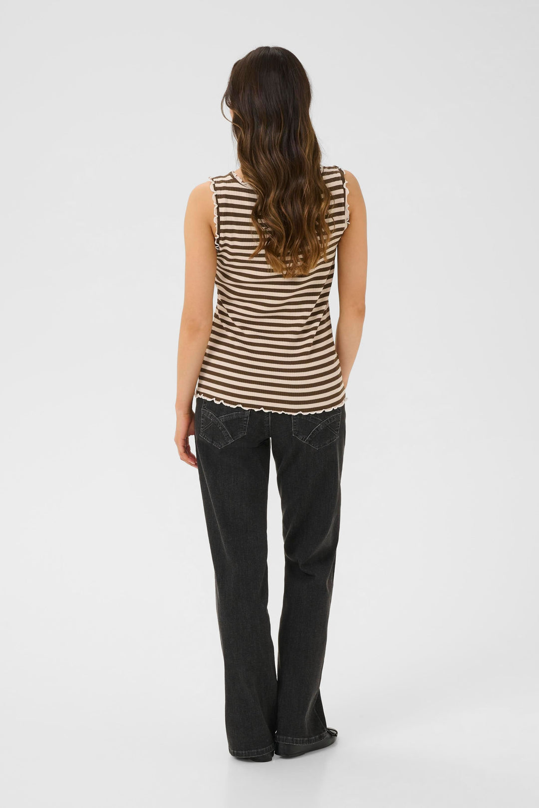 Camisole rayée en tricot côtelé avec finitions ondulées, portée avec un jean noir.