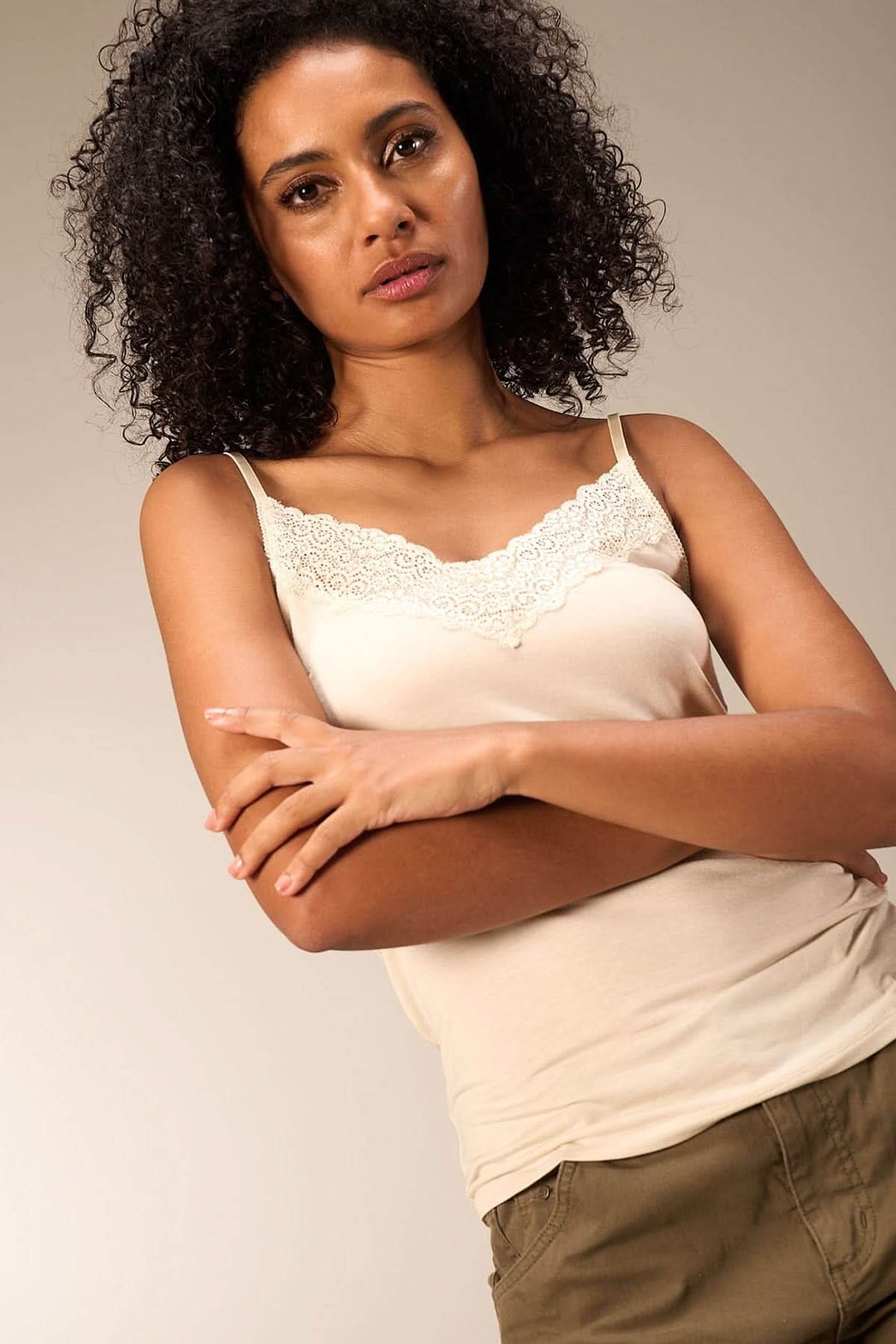 Camisole en beige avec dentelle délicate, fines bretelles, coupée près du corps, pour un look élégant et confortable.