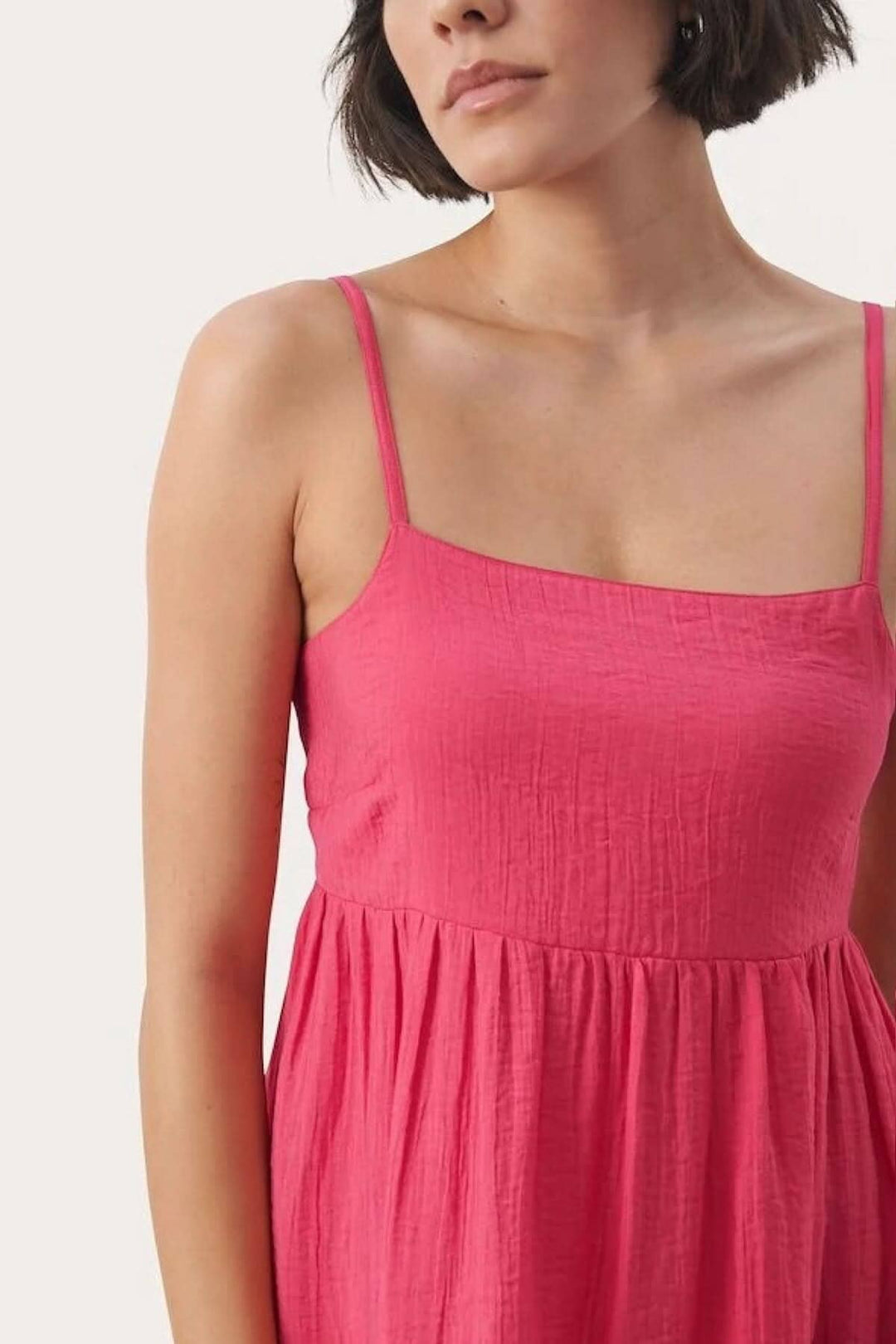 Robe soleil Elyona en rose, avec bretelles fines et tissu léger, parfaite pour les occasions décontractées.
