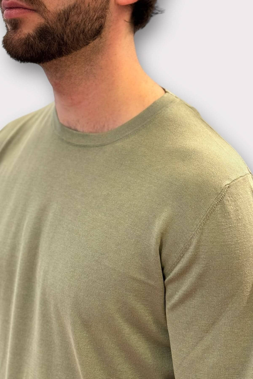 Chandail en coton et soie vert mousse pour homme, offrant confort et luxe.