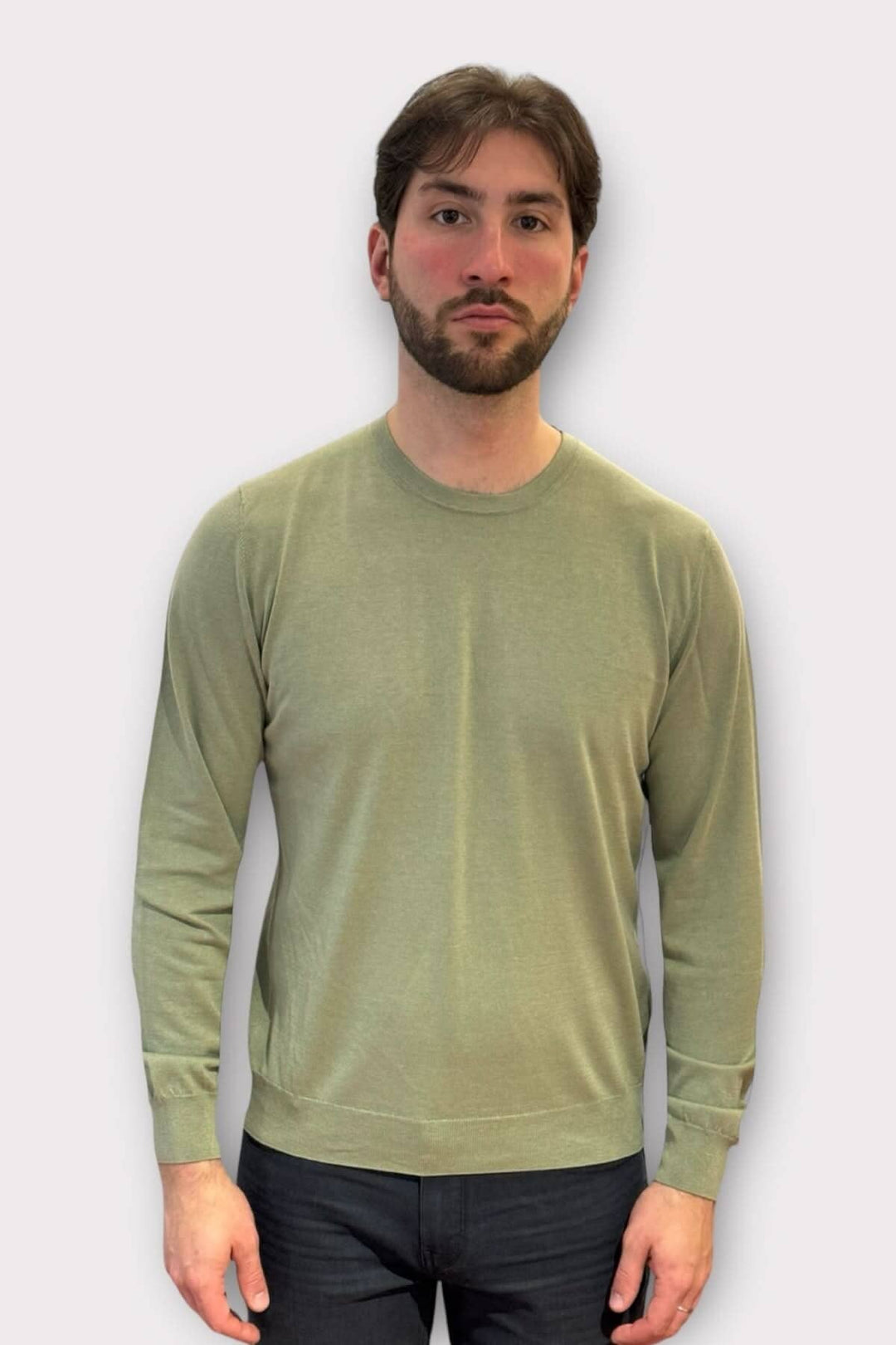 Homme portant un chandail en coton et soie de couleur vert mousse, à manches longues, dans un style décontracté.