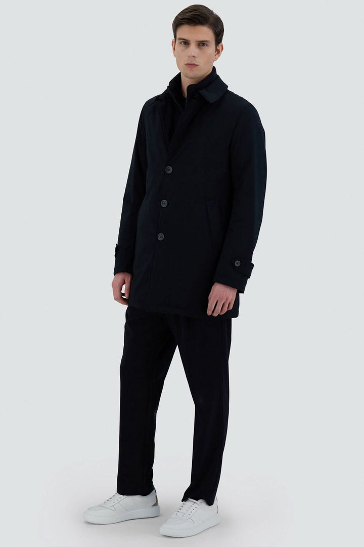 Homme portant un trench-coat noir, élégant et moderne, avec un style classique et coupe régulière.