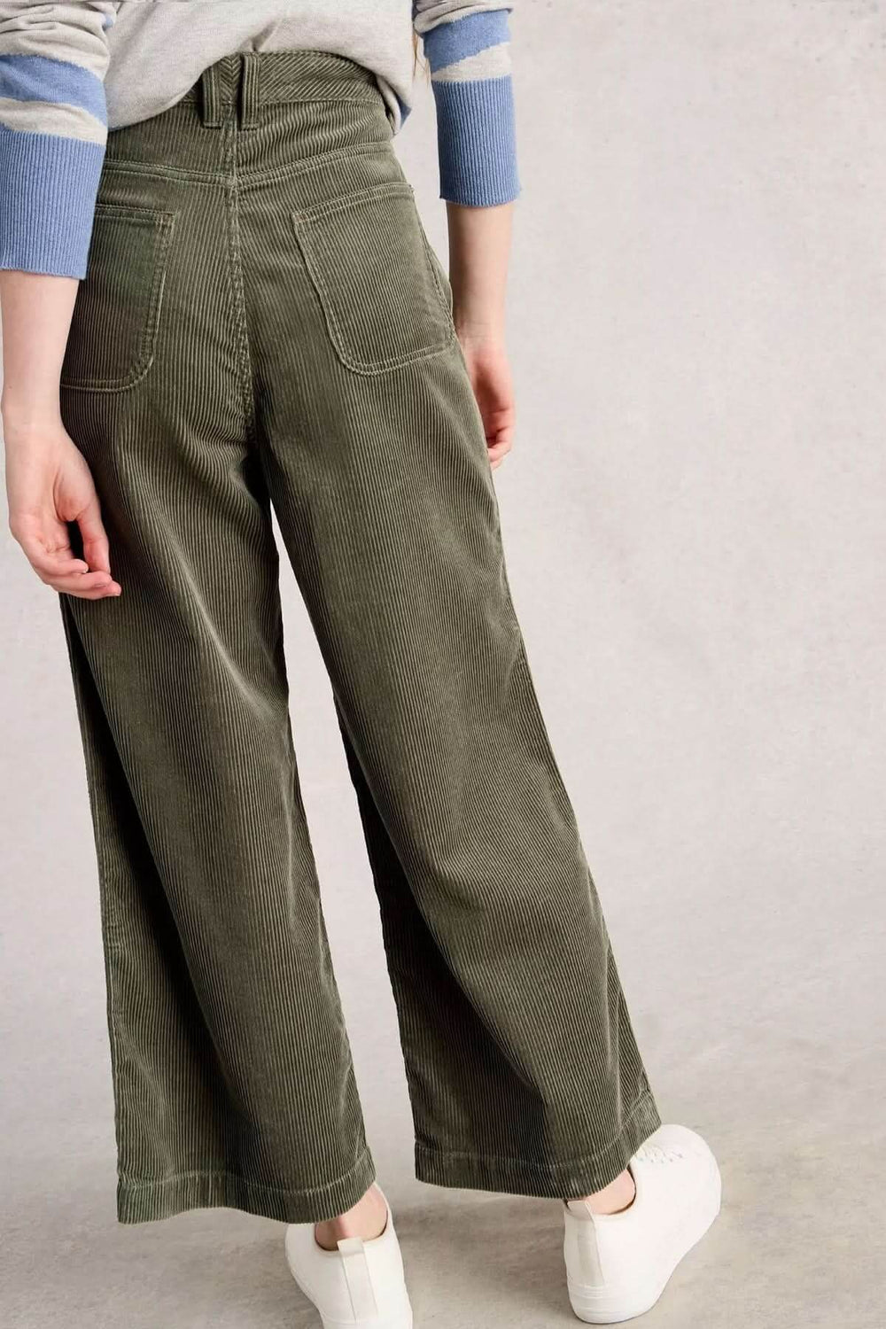 Pantalon Tia en velours côtelé vert avec coupe évasée, vue de dos; parfait pour un style moderne et confortable.