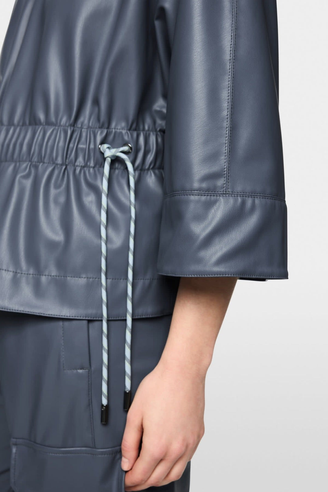 Side view of a black Marc Cain faux leather jacket for women with an exposed zipper - Valérie Simon