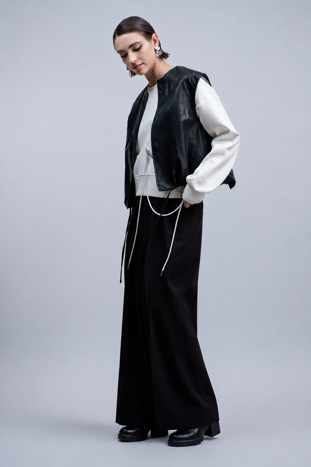 Side view of Haako black women's faux leather sleeveless jacket with pockets - Valérie Simon