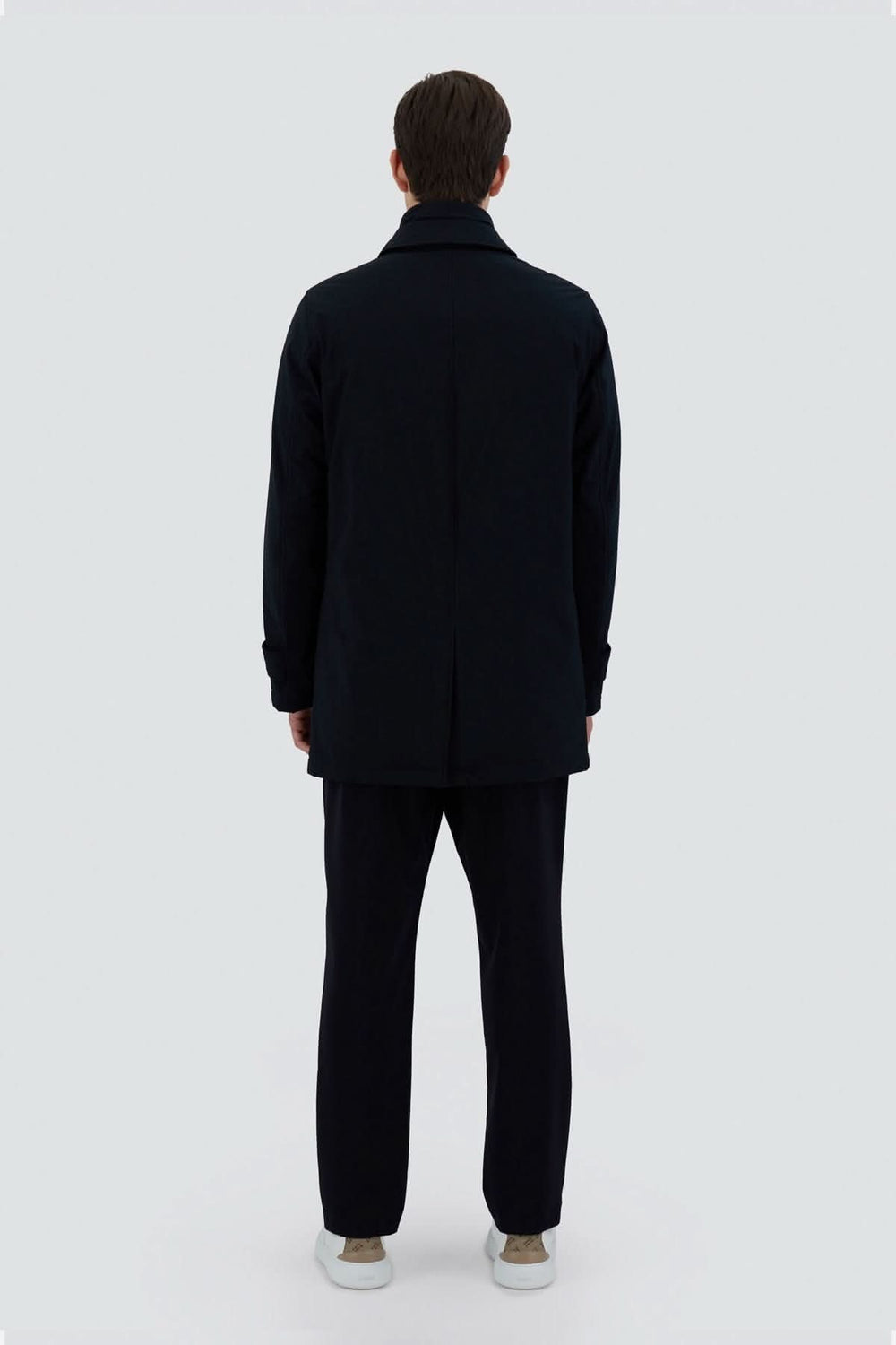 Trench-coat noir en tissu extensible, vu de dos, moderne et élégant pour la ville.