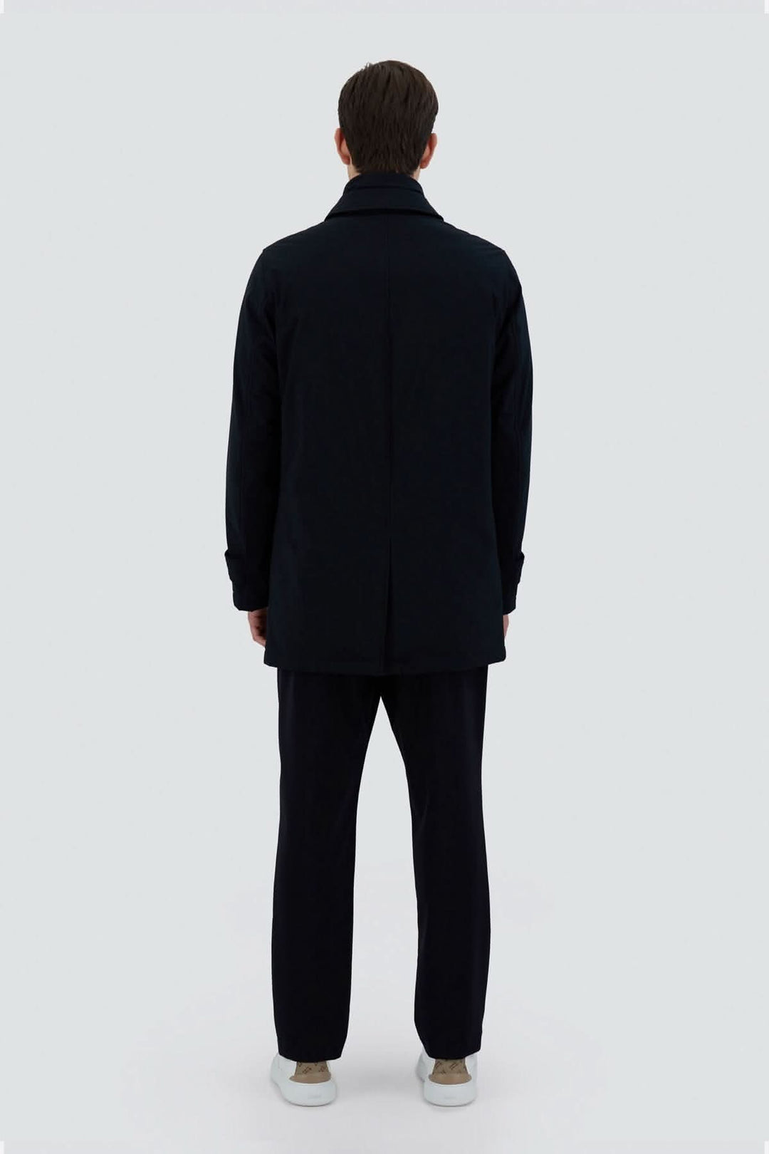 Trench-coat noir en tissu extensible, vu de dos, moderne et élégant pour la ville.