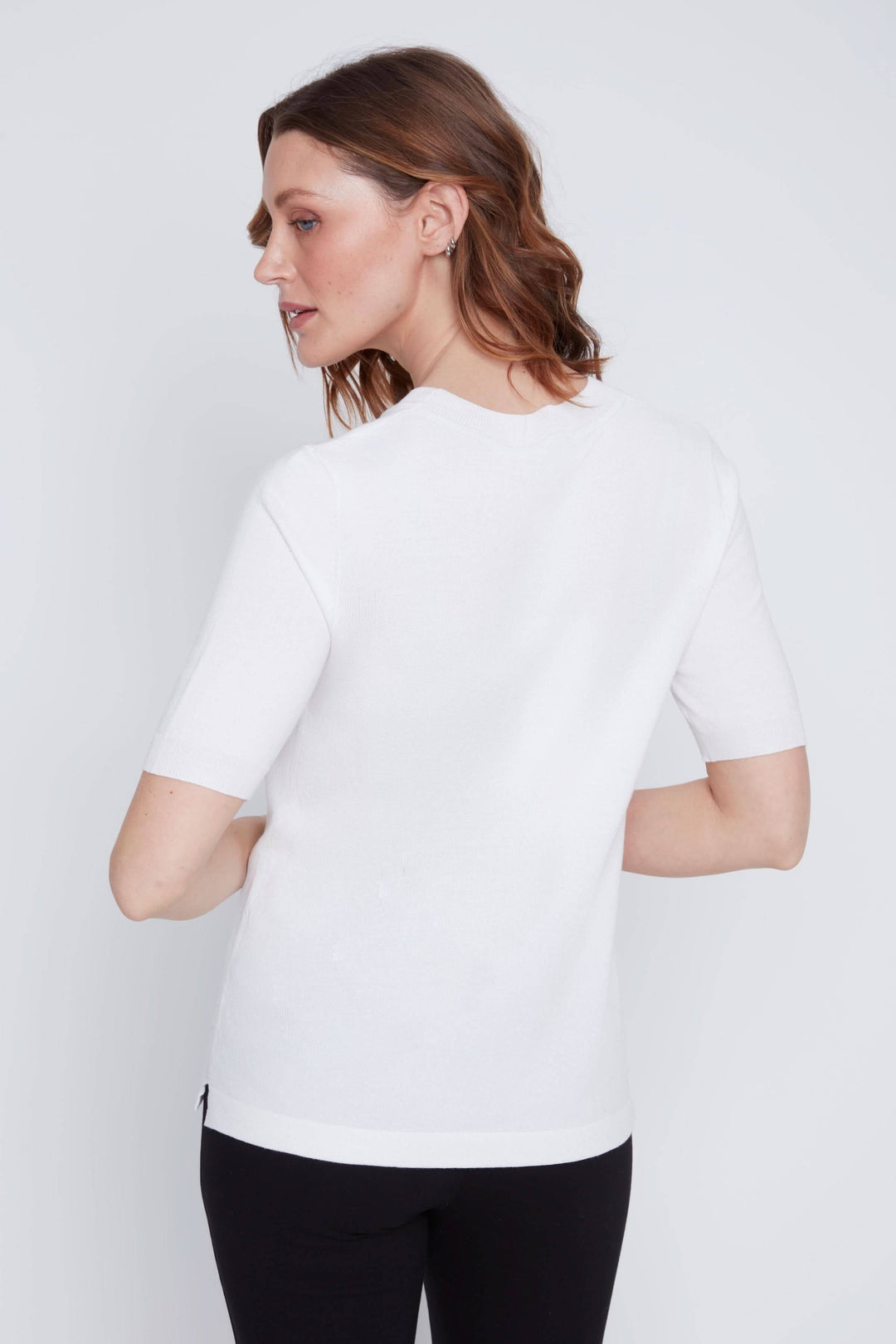 Femme portant un t-shirt classique à manches courtes, vue arrière, en tissu blanc, coupe droite.