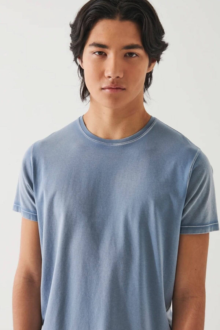 Homme portant un t-shirt vintage wash en coton pima, couleur bleu, à manches courtes et col ras du cou.