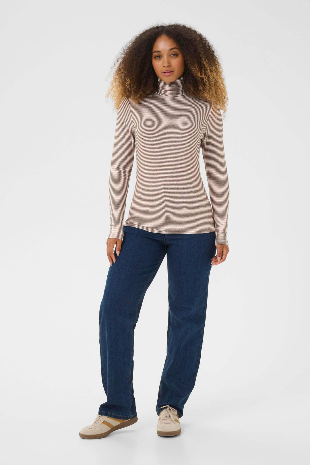 Femme portant le Chandail Amma à col roulé rayé ajusté, offrant confort et style avec une coupe ajustée et extensible.