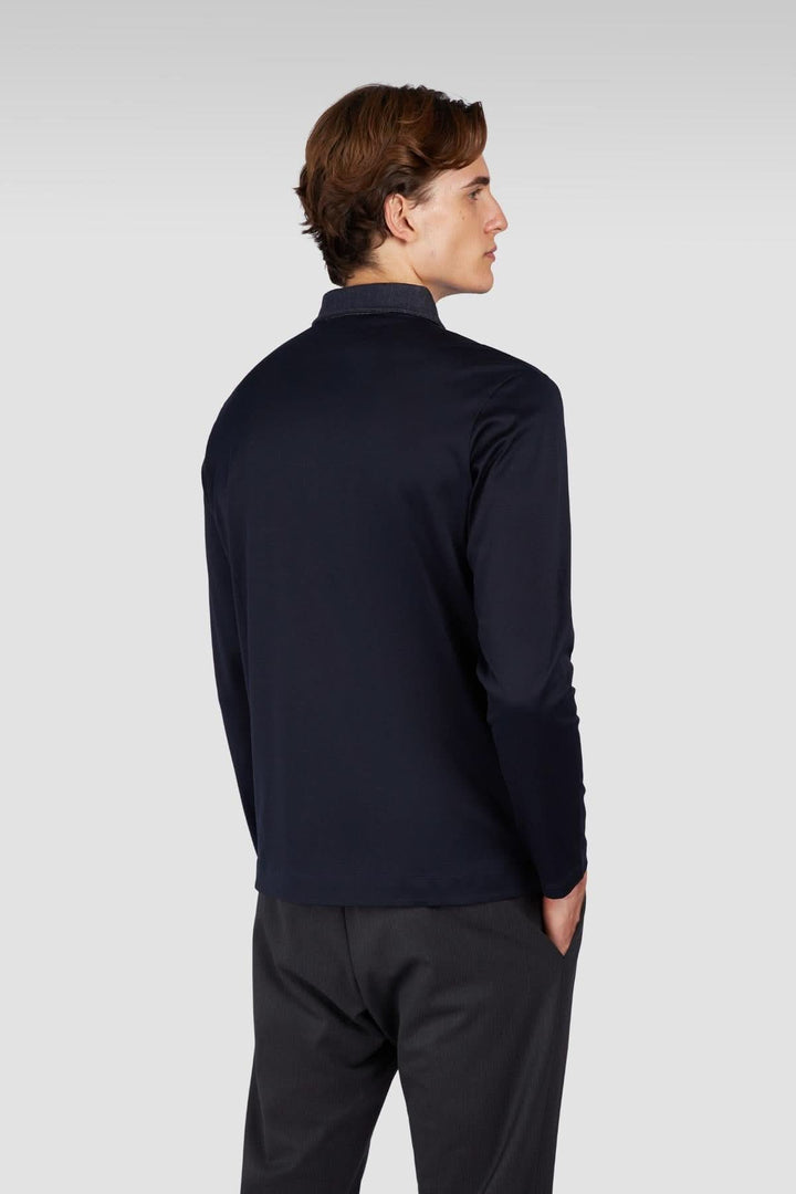 Homme portant un polo manches longues en coton noir vu de dos avec col contrastant.