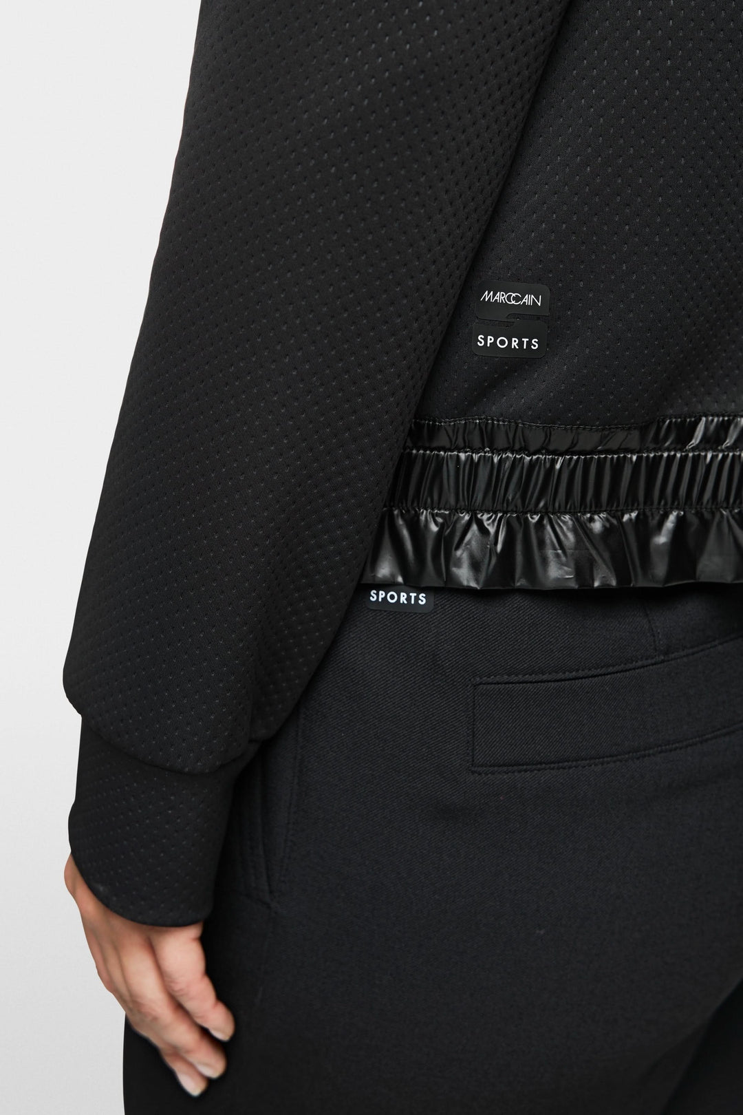 Veste zippée noire à capuchon, finition satinée et taille élastiquée, parfaite pour un look sportif et moderne.