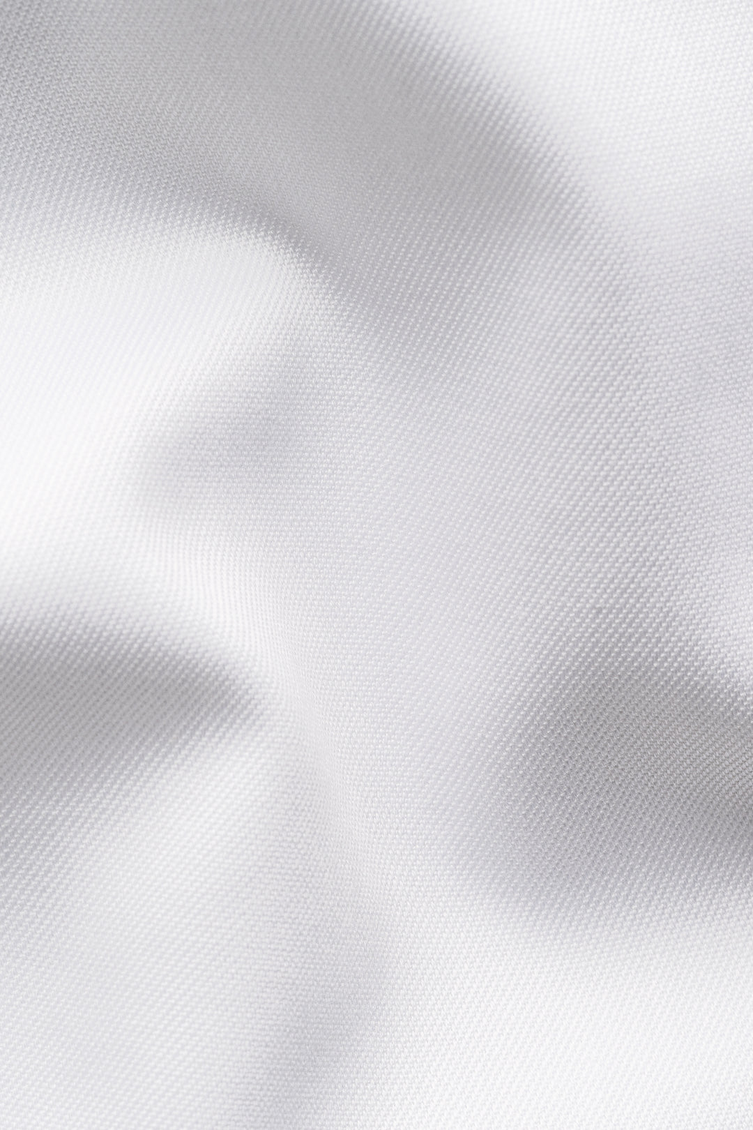 Tissu blanc élégant et texturé, idéal pour une chemise habillée raffinée et confortable.