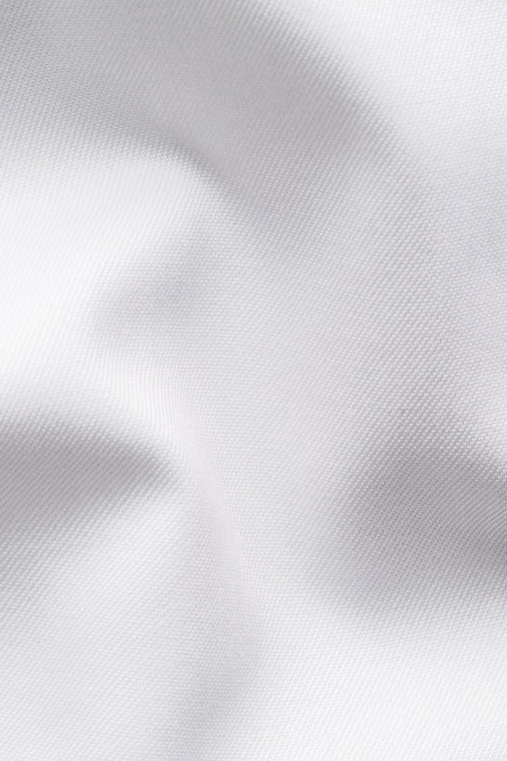 Tissu blanc élégant et texturé, idéal pour une chemise habillée raffinée et confortable.
