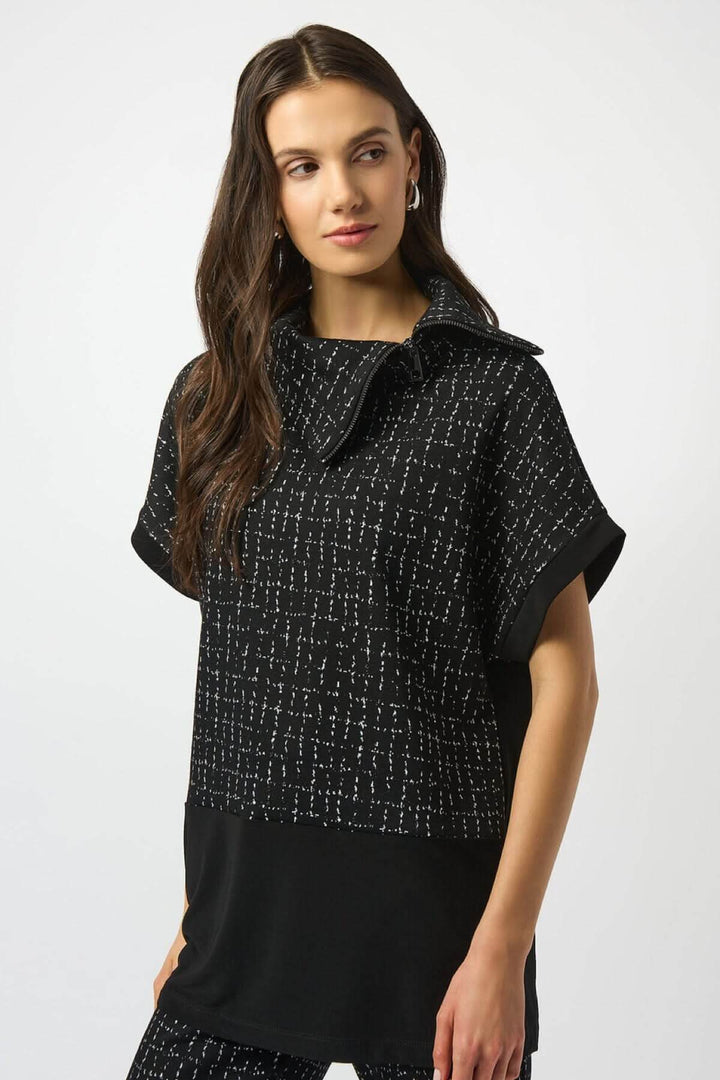 Haut noir à col asymétrique, manches courtes, motif quadrillage blanc, élégant et moderne.