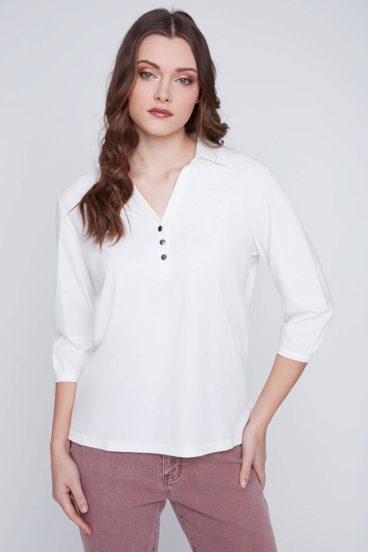 Blouse blanche à manches 3/4 avec encolure en V et patte de boutonnage, style élégant et décontracté.