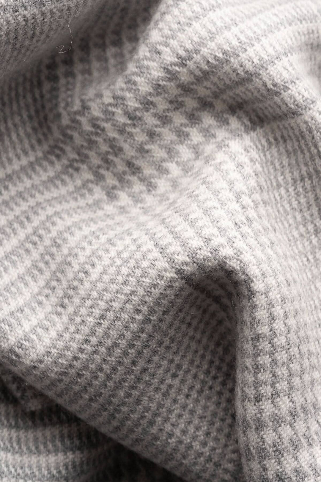 Foulard en laine à motif Prince de Galles en gris clair et blanc, texture douce et chaleureuse.